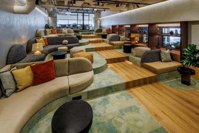 Aufsteigende Sitzreihen im hauseigenen Kino des Novotel Tallinn mit gemütlichen Sofas und Kissen