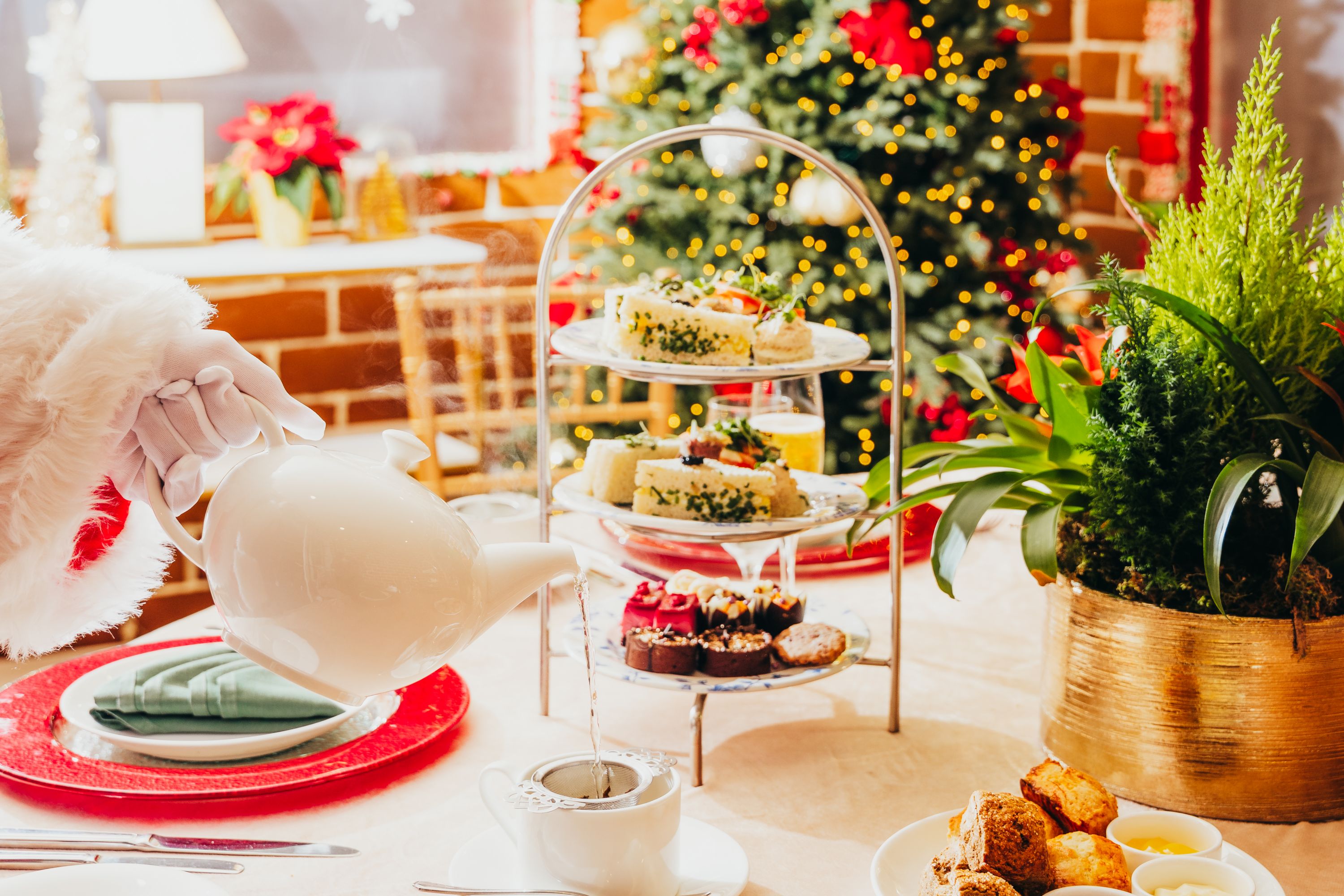 Santa pouring tea for holiday tea in the gingerbread house
