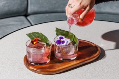 Cocktails créatifs décorés avec des fleurs, servis au bar du TRIBE London Canary Wharf 