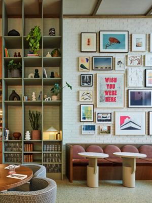 Objets décoratifs, banquettes roses et tableaux accrochés au mur dans le restaurant du TRIBE London Canary Wharf