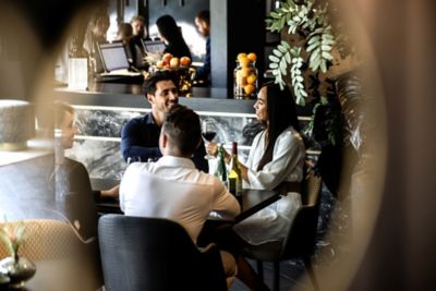Deux couples d’amis qui prennent un verre de vin au bar de l’hôtel Le Marin Hotel Rotterdam City