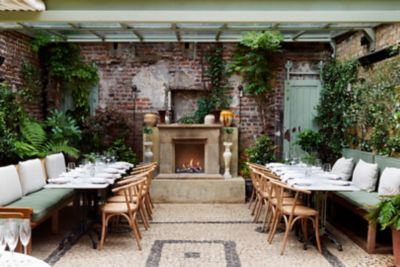 Exposed brick walls, greenery and a fireplace at fine dining restaurant Luca in London