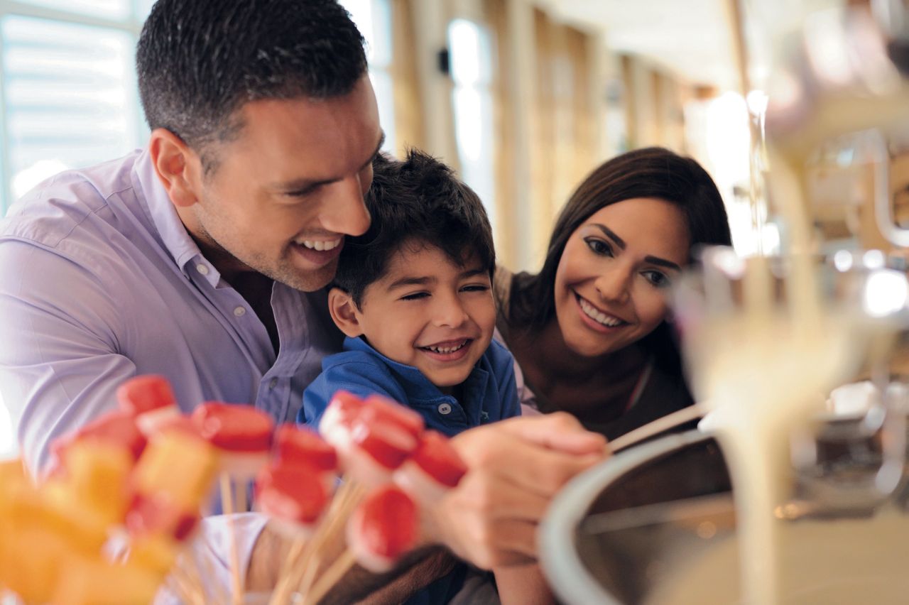 Family enjoying a chocolate fountain at Mövenpick Hotel Jumeirah Lakes Towers in Dubai