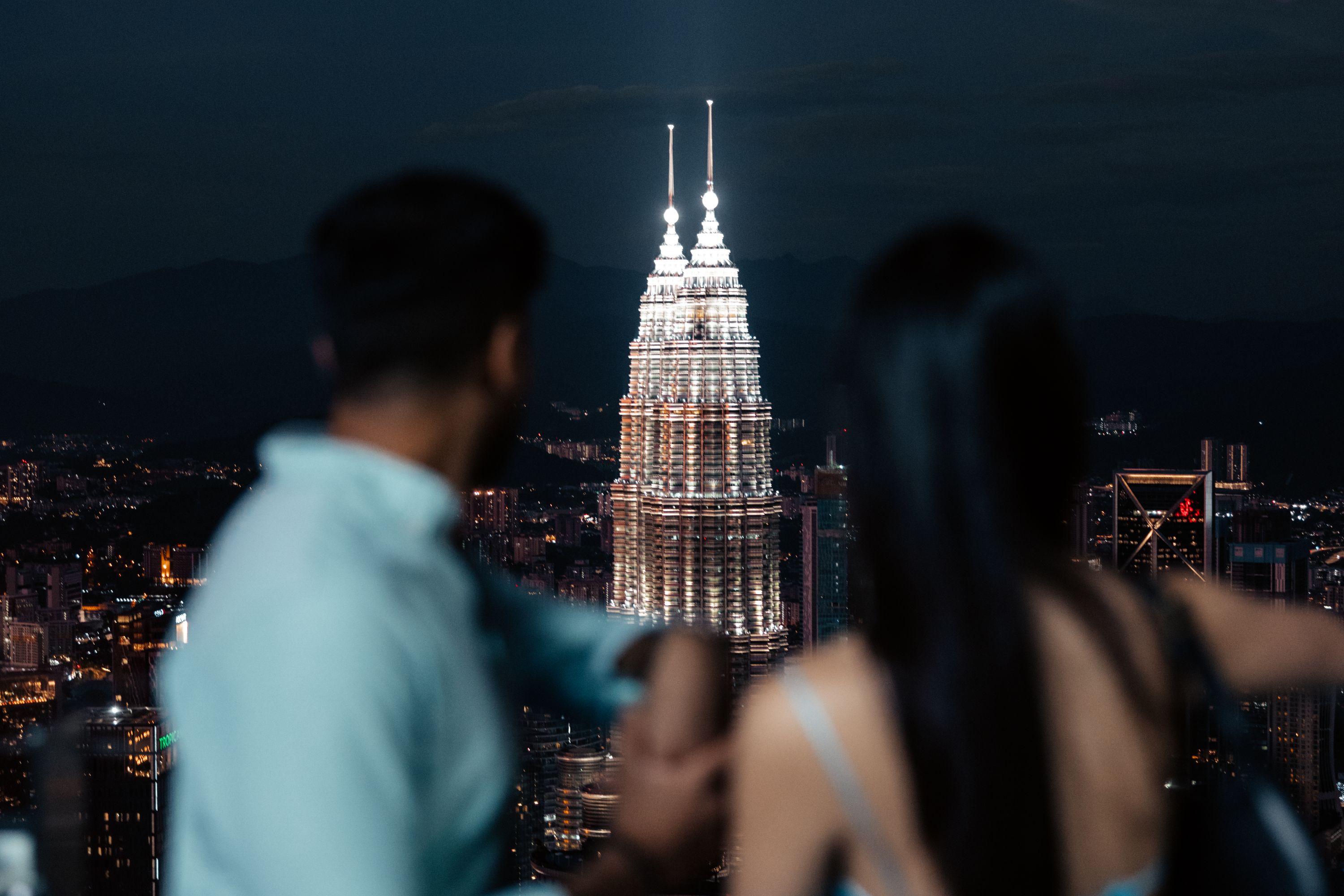 A couple enjoy a view of the Kuala Lumpur skyline at night