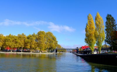 Blue water and a bike path on a sunny day at the peaceful Canal de l’Ourcq, Paris