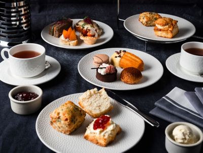 tasses de thé de l’après-midi, pâtisseries, scones et gourmandises sur des assiettes blanches