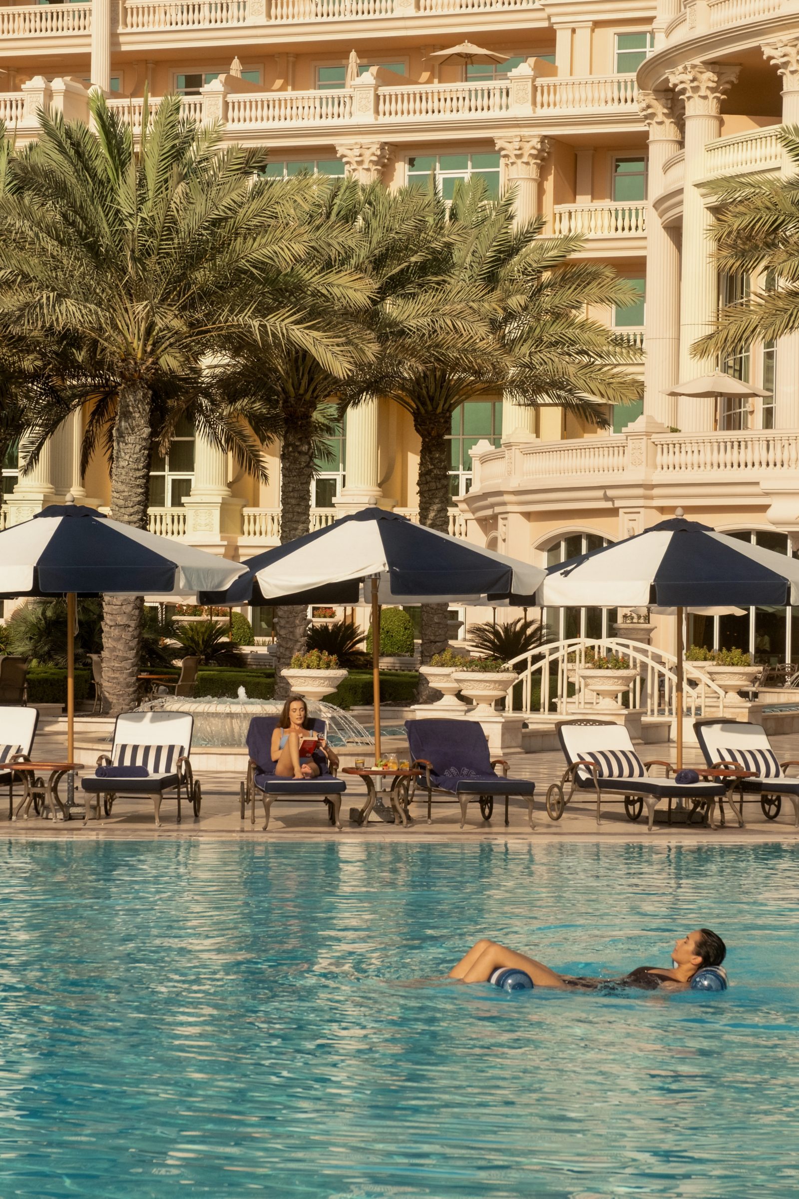 Piscine du Raffles The Palm Dubai avec transats et palmiers