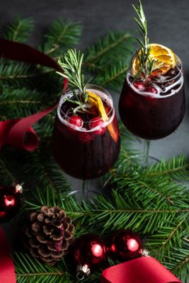 deux verres de sangria rouge à côté d’une guirlande et de décorations