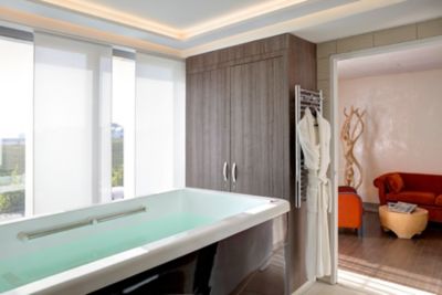 A warm bath, plush robe and relaxing lounge area in a suite at a wellness hotel