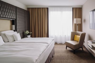 A hotel room at Pullman Berlin Schweizerhof, with cosy bed and large windows