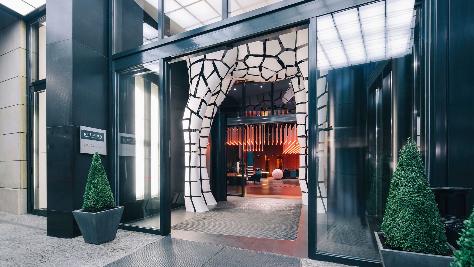 The sleek entrance to Pullman Berlin Schweizerhof hotel, with its zebra sculpture