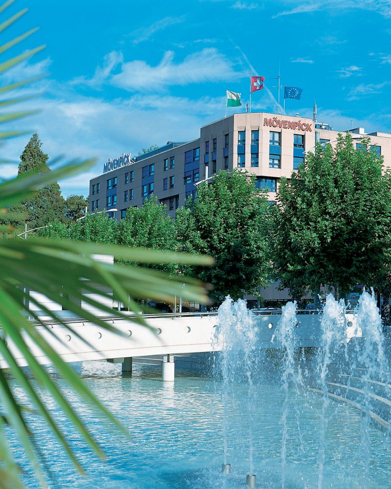 Exterior facade of the Mövenpick Hotel Lausanne with a fountain in the foreground