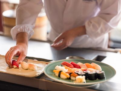 A chef hand-pressing and plating sushi at Le Benkay Japanese restaurant, Paris