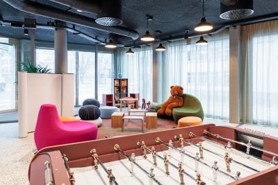 Lobby im ibis Styles Bern City mit bunten Sesseln, großem Plüschteddy und Tischfußball