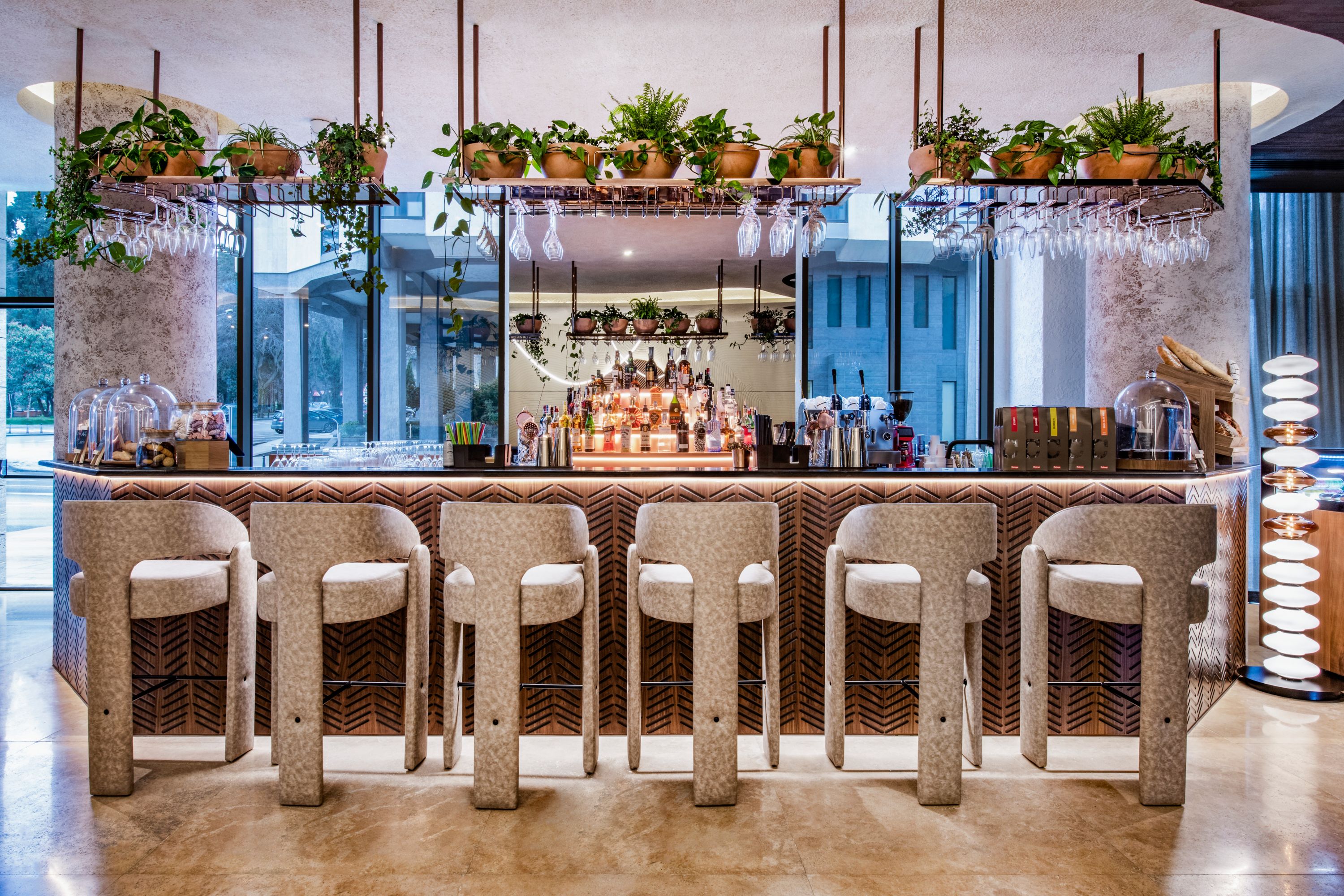 Tabourets et décoration végétalisée au bar de l’hôtel 5 étoiles Swissôtel Tbilisi