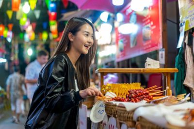 Woman enjoying street food at a night market