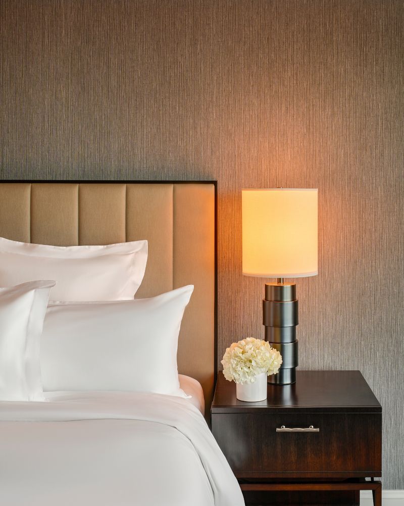 A bed and nightstand with a lamp