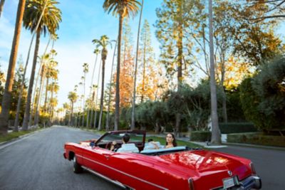 A woman in a red convertible