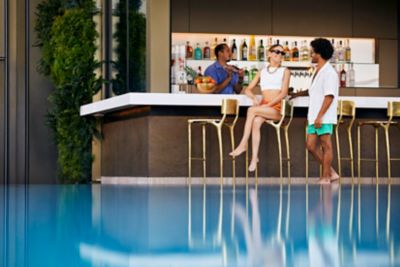 Two people at a bar next to a pool
