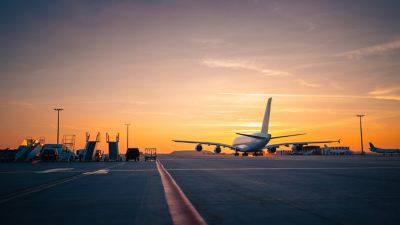 mão segurando passaportes e uma miniatura de um avião