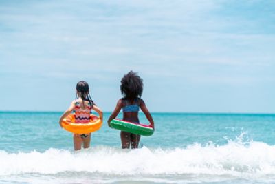 crianças com boia brincando na praia